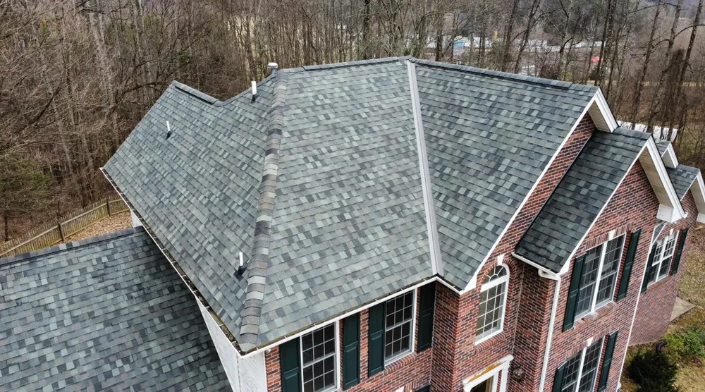 Two-story brick home with a new grey shingle roof by White's Roofing Co in Bristol, TN