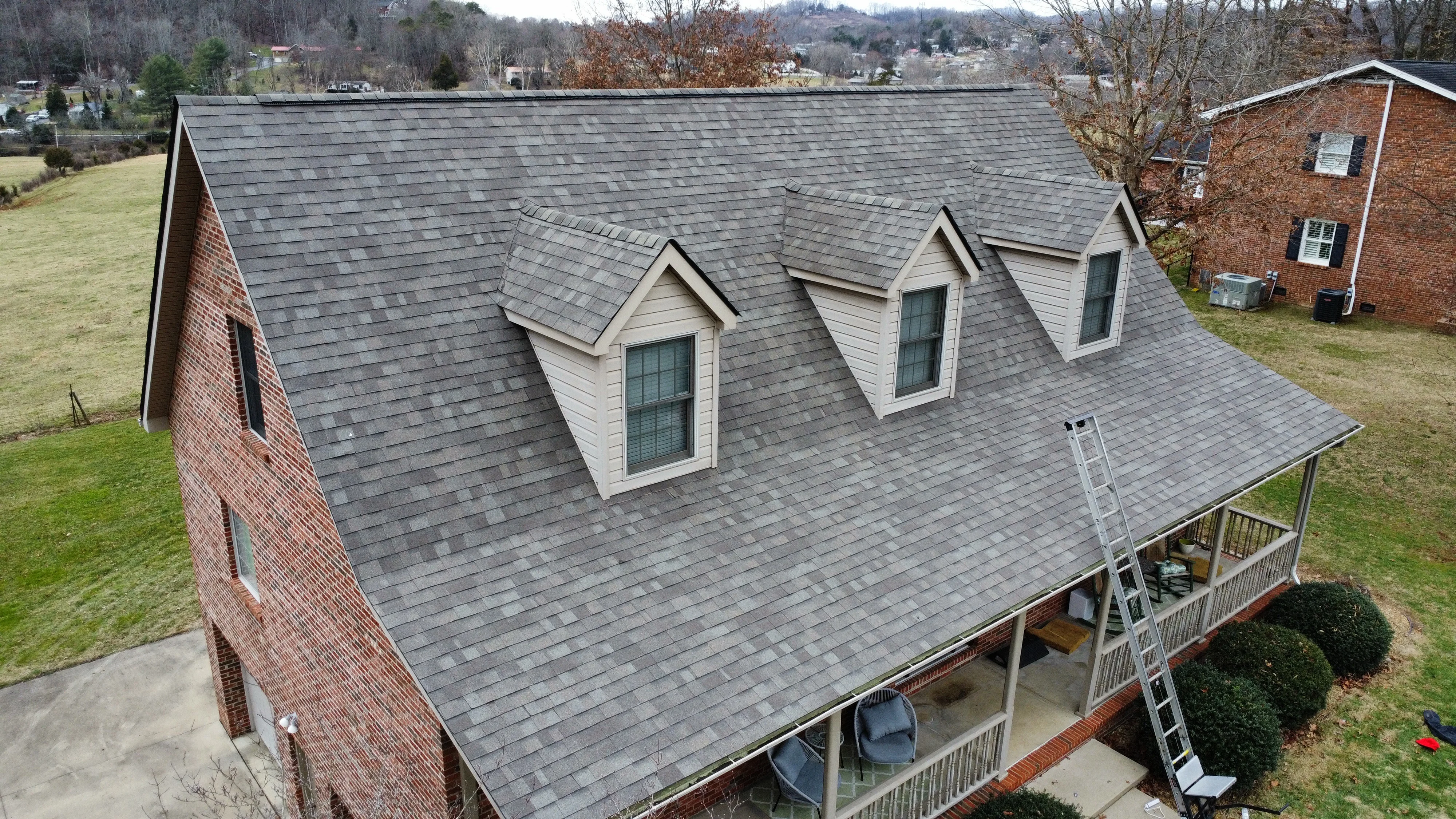 Brick home with dormer windows and a grey shingle roof - roofing in Bristol, TN