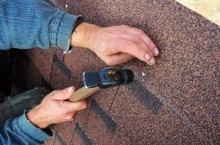 Close-up of a hammer being used for a shingle roof repair in Bristol, TN